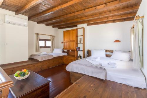 a bedroom with two beds in a room with wooden ceilings at Crystal Dream Paros in Ekatondapilianí