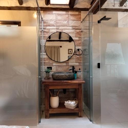 a bathroom with a shower and a vanity with a mirror at Posada Iglesia Vieja in Soatá