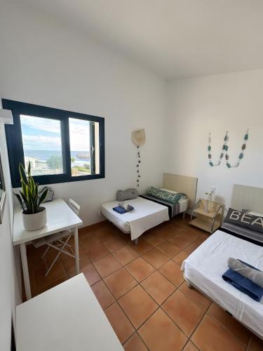 een kamer met twee bedden en een raam bij Duplex Laura in Punta Grossa