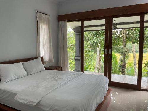 ein Schlafzimmer mit einem Bett und einem großen Fenster in der Unterkunft Edwin's Stay in Penebel