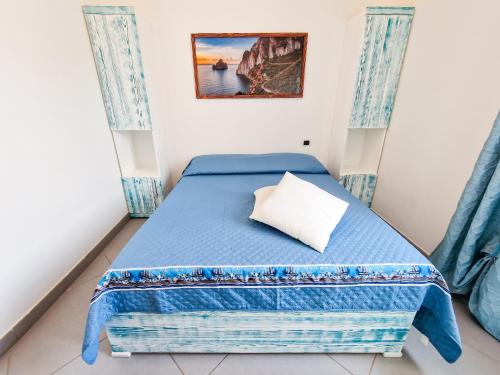 una camera con letto blu e cuscino di Villa Corallo ad Alghero