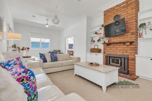 a living room with a couch and a fireplace at Home at Haverfield in Echuca