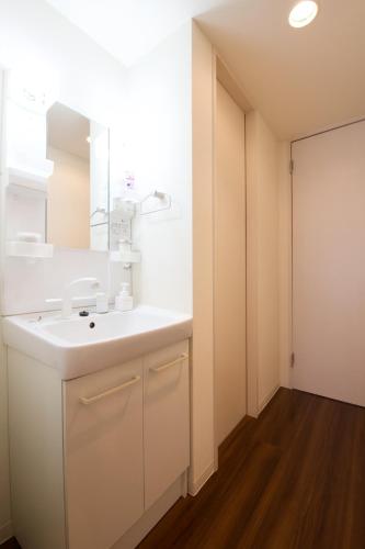a bathroom with a white sink and a mirror at Chill Place 125 Kameari in Tokyo