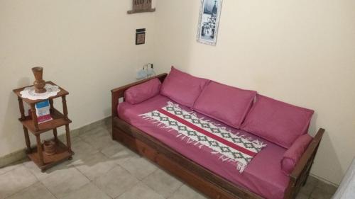 a purple couch in a room with a side table at a TRES MIN DEL CENTRO in Concordia