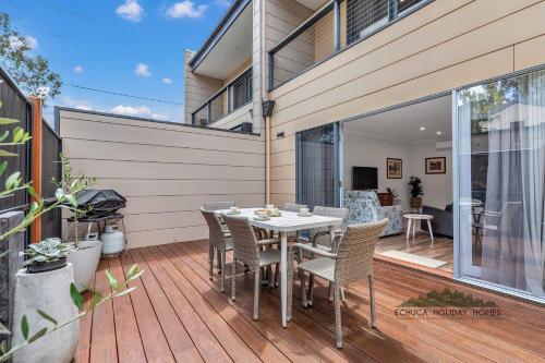 eine Terrasse mit Tisch und Stühlen auf einem Deck in der Unterkunft Campaspe Central - Your Central Echuca Escape! in Echuca