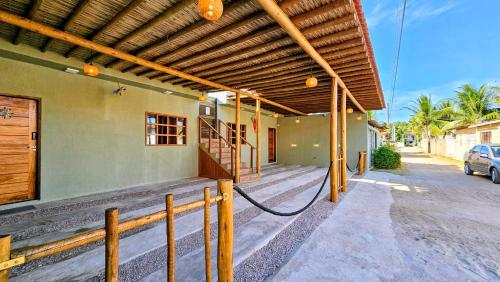 un bâtiment avec une pergola en bois dans une rue dans l'établissement Casas Costa Dos Corais, à Japaratinga