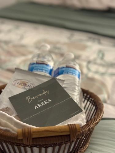 two water bottles in a basket with a book at Casa Areka in Veracruz