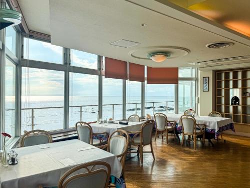 a restaurant with tables and chairs and large windows at #43 凪-Nagi- in Yokosuka