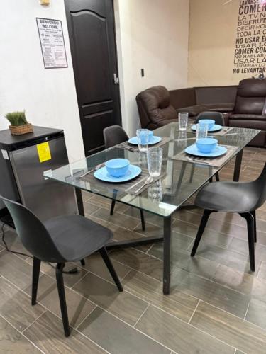 a glass table and chairs in a living room at Suite La Lomita #4 Climatizada in Tuxtla Gutiérrez