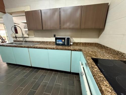 a kitchen with a counter with a sink and blue cabinets at Suite La Lomita #4 Climatizada in Tuxtla Gutiérrez