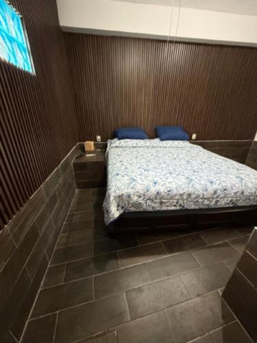 a bedroom with a bed with blue pillows on it at Suite La Lomita #4 Climatizada in Tuxtla Gutiérrez