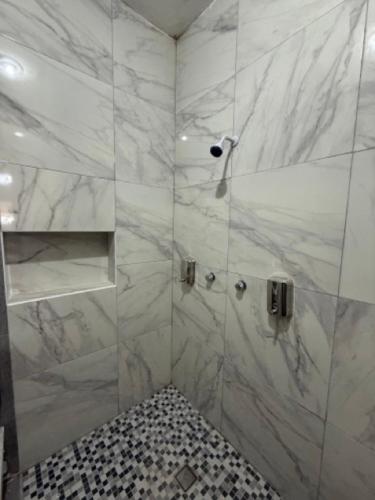a bathroom with a shower with white marble at Suite La Lomita #4 Climatizada in Tuxtla Gutiérrez