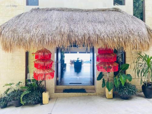 a building with a straw roof and some plants at Villa Umbrella Lombok in Senggigi 