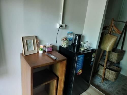 eine Küche mit einem schwarzen Kühlschrank und einem Holztisch in der Unterkunft Baan Boy in Ko Kood