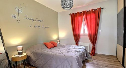 een slaapkamer met een bed met rode gordijnen en een tekst op de muur bij Villa Flora in Balazuc