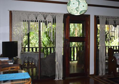 a living room with a door and a balcony at Oskar's Rain Forest Retreat in Nelly Bay