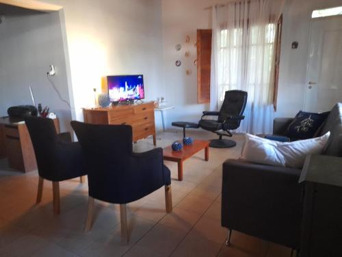 a living room with a couch and chairs and a tv at Cómoda casa en centro de Jachal in San José de Jáchal