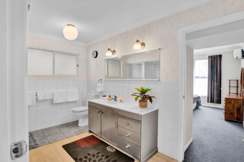 a white bathroom with a sink and a toilet at No 1 Beachfront Holiday Home in New Plymouth