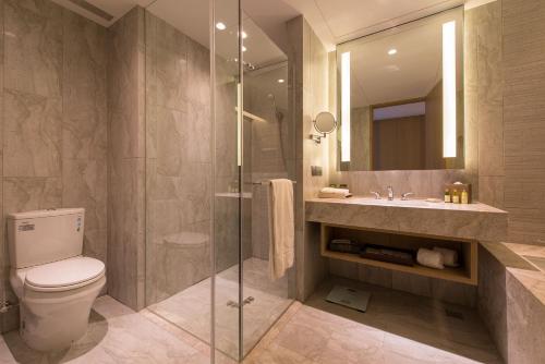 a bathroom with a shower and a toilet and a sink at Golden Lake Hotel in Jinhu