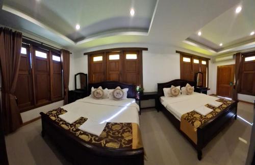 a bedroom with two beds and wooden cabinets at Vang Vieng Moment Resort in Vang Vieng