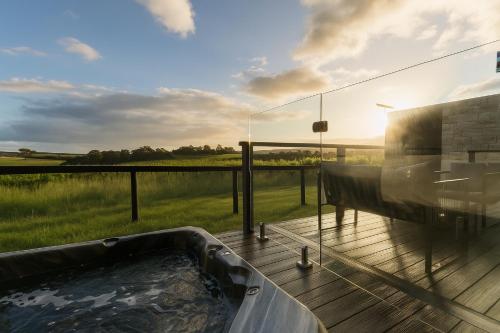 a glass house with a hot tub on a deck at Vineyard Villa in McLaren Vale