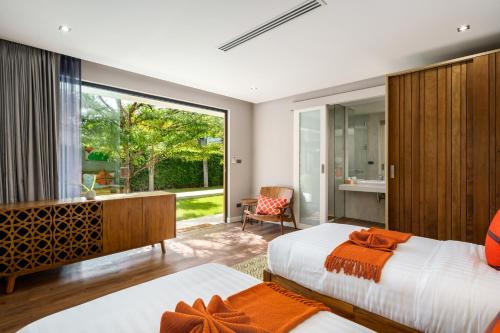 a bedroom with two beds and a large window at 班塔莱海滨之家1号 in Koh Samui