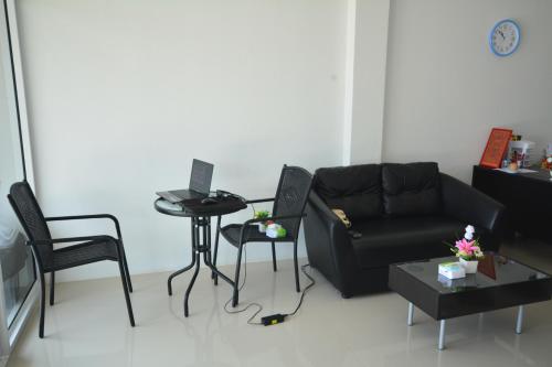 a living room with a couch and a table at JC Guesthouse @ Suratthani Airport in Surat Thani