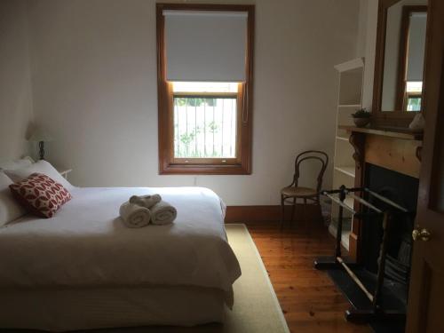 a bedroom with a bed with two towels on it at Maylands Cottage in Evandale
