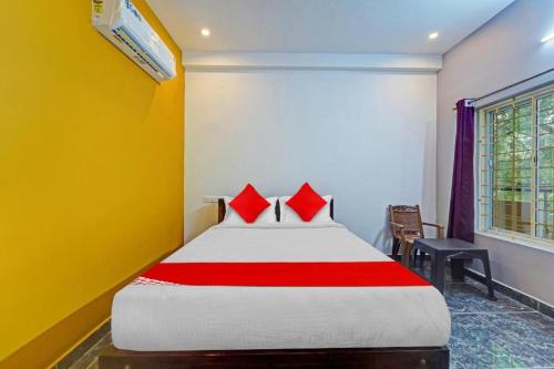 a bedroom with a large bed with red pillows at Jardin Paradise in Puducherry