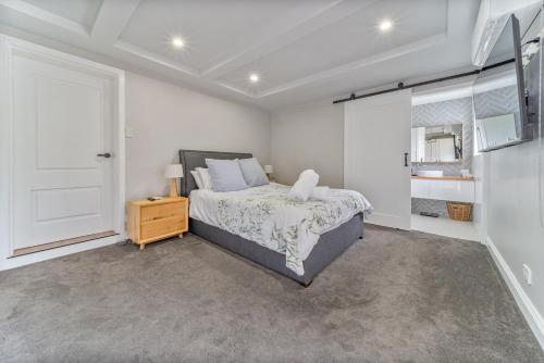 1 dormitorio con 1 cama, mesita de noche y ventana en 5min to CBD and Sleeps 9 with Spa and EV charger, en Quarry Hill