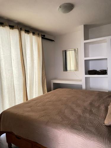 a bedroom with a bed and a window with curtains at PH 41 Metepec in Toluca