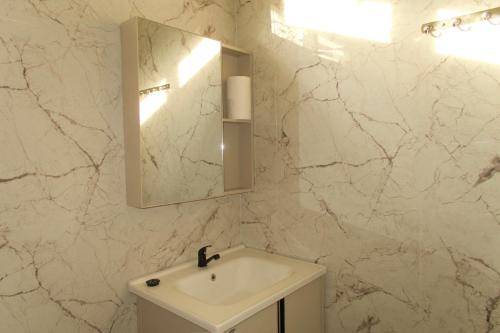 Un baño blanco con lavabo y espejo. en Villa Pangkung, en Uluwatu