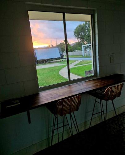 two chairs sitting under a window in a room at Blue Dolphin Caravan Park Yeppoon in Yeppoon