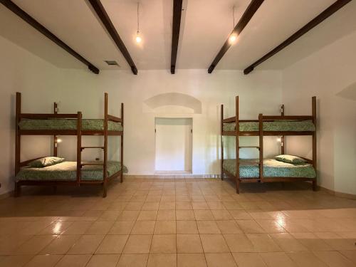 2 stapelbedden in een kamer met een gang bij Old House Hostel in Sucre
