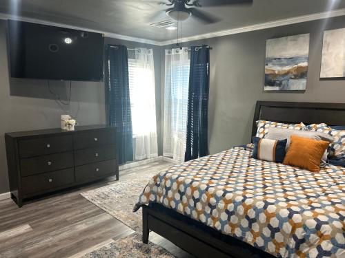 Un dormitorio con una cama, una cómoda y un televisor. en Bannock Manor, en Memphis