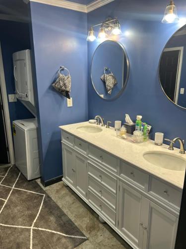 Baño azul con 2 lavabos y 2 espejos en Bannock Manor, en Memphis