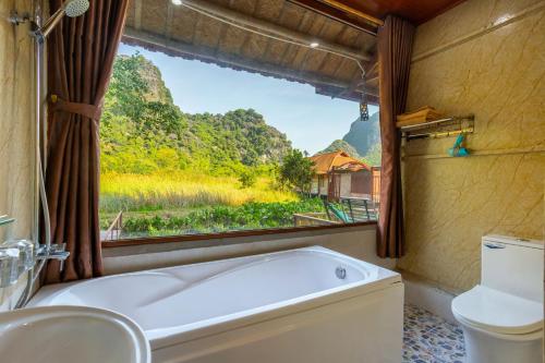 un bagno con vasca e finestra di Lotus Field Homestay a Ninh Binh