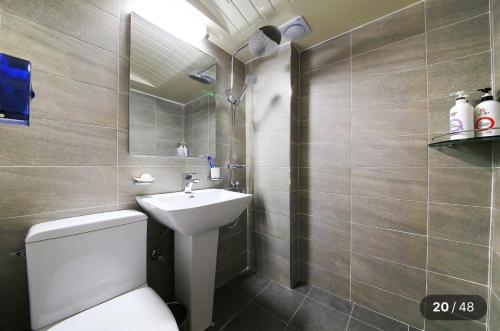 Un baño con un inodoro blanco y un lavabo. en KANU hotel, en Seúl