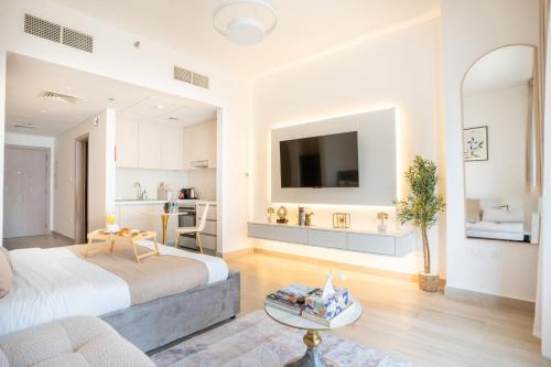 a bedroom with a bed and a living room at Chic Studio l Waters Edge l Top Location in Yas island l Canal view with Balcony l Free Parking l Near Yas Mall l F1 Yas Island l Sea world in Abu Dhabi