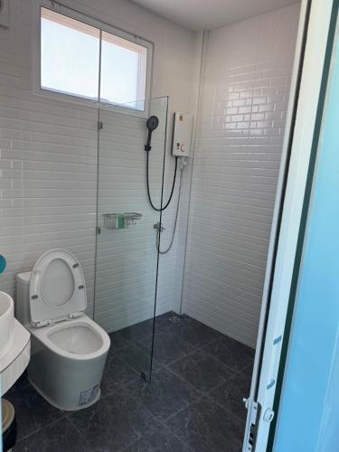 a bathroom with a shower with a toilet and a glass door at Twocans Homestay KohMak - SHA in Ko Mak