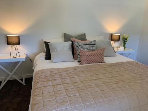 MintaroTickles Cottage in a beautiful Rural Setting的一间卧室配有一张大床、枕头和两盏灯。