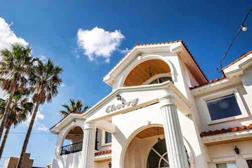 a white building with palm trees in front of it at Stay Cherry in Namwon