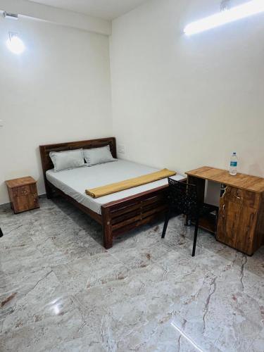 a bedroom with a bed and a desk and a table at Dubai Inn in Kanjirapalli
