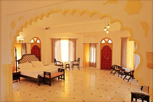 Una sala de estar con una cama, una mesa y sillas. en GOVIND GARH NATHDWARa, en Nathdwara