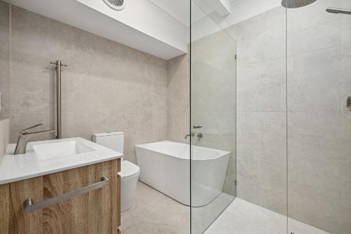 a bathroom with a toilet and a sink and a shower at Galoola Hidden Gem - 2,97 Galoola Drive, Rooftop outdoor area with spectacular views, Wi-Fi and air conditioning. in Nelson Bay