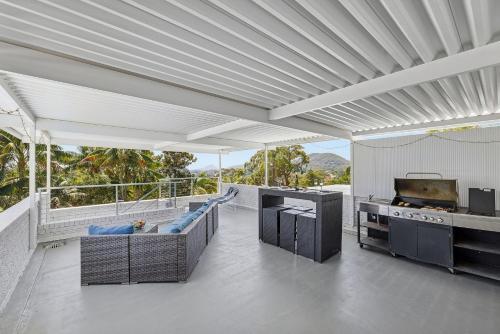 a large living room with a kitchen and a grill at Galoola Hidden Gem, 2-97 Galoola Drive, Rooftop outdoor area with spectacular views, Wi-Fi, Air Conditioning, Pet Friendly in Nelson Bay