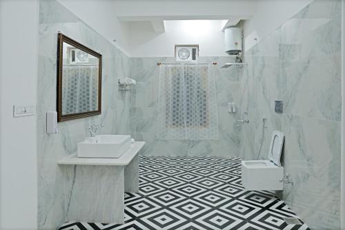 Un baño blanco con lavabo e inodoro. en GOVIND GARH NATHDWARa, en Nathdwara