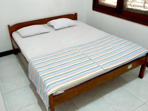 ein Bett mit zwei Kissen darauf in einem Zimmer in der Unterkunft Hotel Wijaya Magelang in Magelang