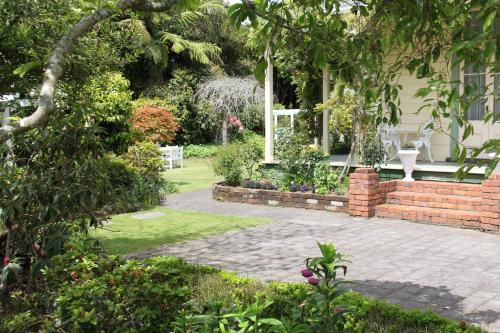 a garden with a brick wall and a patio at Regan House in Stratford