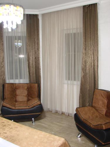 two chairs in a hotel room with curtains at Villa Royal House in Makhinjauri